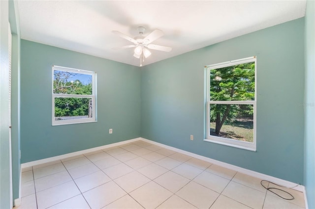 unfurnished room featuring light tile patterned floors, a ceiling fan, and baseboards