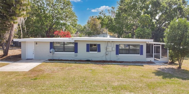 view of front facade with a front yard and a sunroom