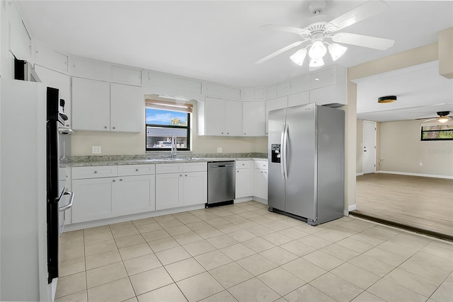 kitchen featuring white cabinetry, stainless steel appliances, a ceiling fan, and a sink