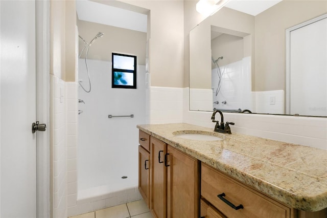 full bathroom with vanity, a stall shower, wainscoting, and tile patterned flooring