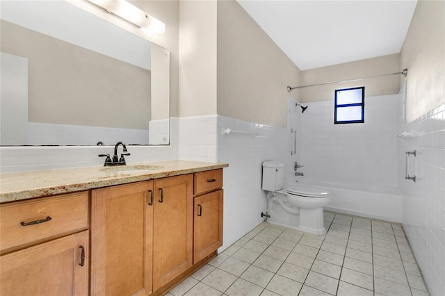 full bathroom featuring tile patterned floors, toilet, tile walls, bathing tub / shower combination, and vanity