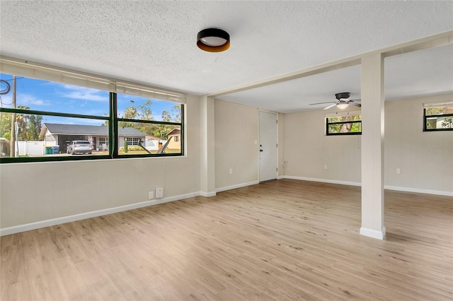 spare room featuring ceiling fan, a textured ceiling, baseboards, and wood finished floors