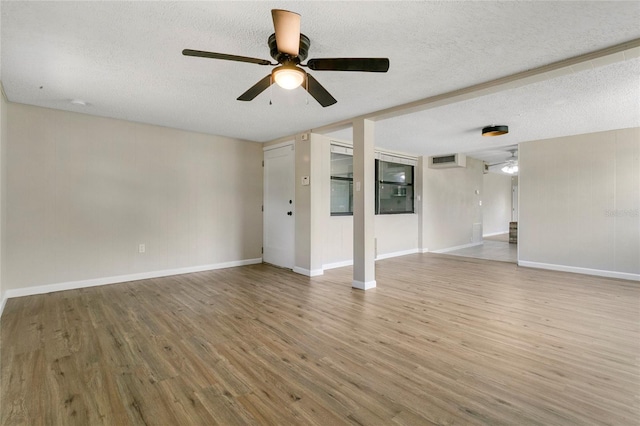 spare room featuring visible vents, baseboards, ceiling fan, light wood-type flooring, and a textured ceiling