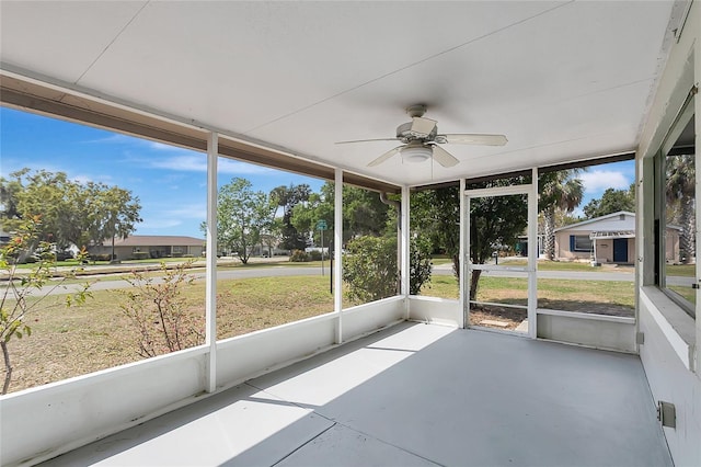 unfurnished sunroom featuring ceiling fan