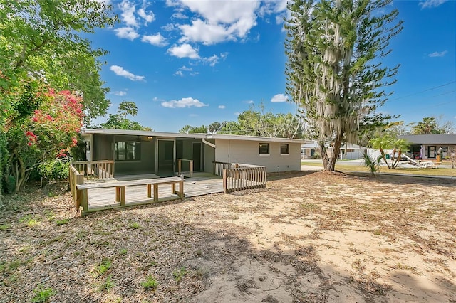 rear view of house featuring a wooden deck