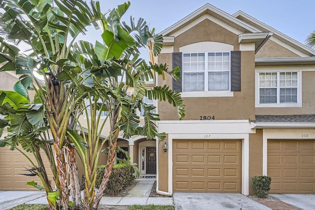 view of property with an attached garage and stucco siding