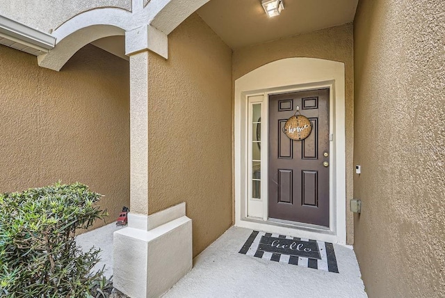 view of exterior entry featuring stucco siding