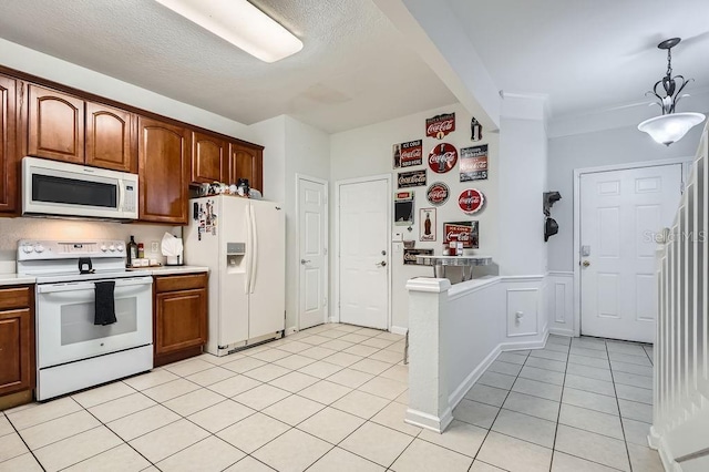 kitchen featuring white appliances, light tile patterned flooring, hanging light fixtures, light countertops, and a textured ceiling