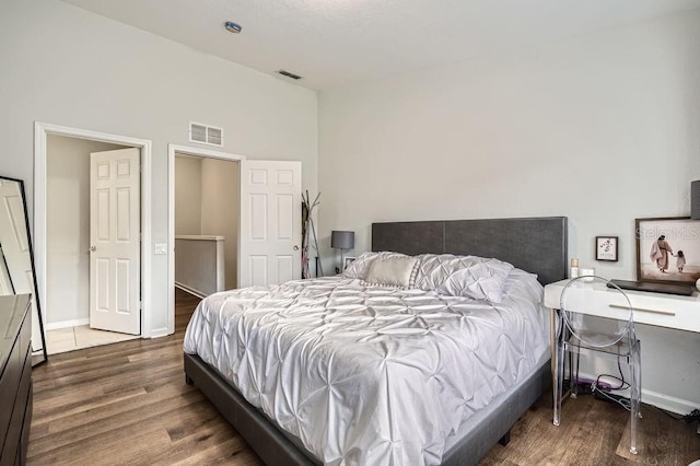 bedroom with visible vents, baseboards, and wood finished floors