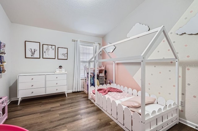 bedroom featuring baseboards, dark wood-type flooring, and a textured ceiling
