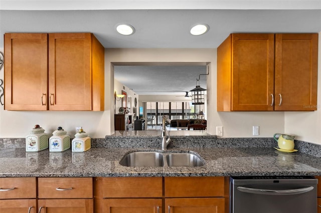 kitchen featuring a sink, brown cabinets, stainless steel dishwasher, and dark stone countertops