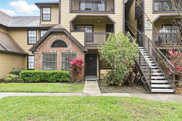 property entrance with a lawn and brick siding