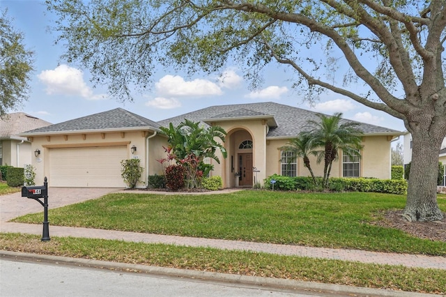 ranch-style home featuring an attached garage, a front lawn, roof with shingles, stucco siding, and driveway