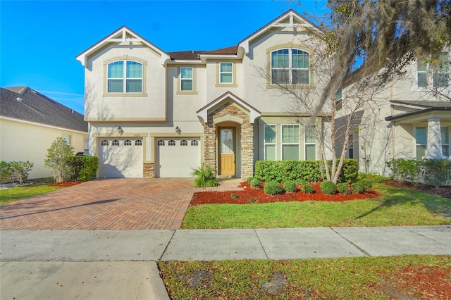 view of front of property with a garage, decorative driveway, stone siding, and stucco siding