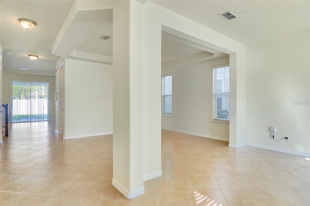 unfurnished room with light tile patterned floors, visible vents, and baseboards