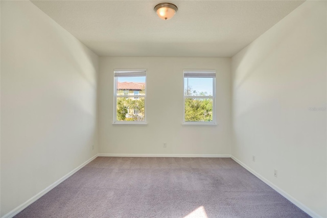 carpeted empty room with baseboards