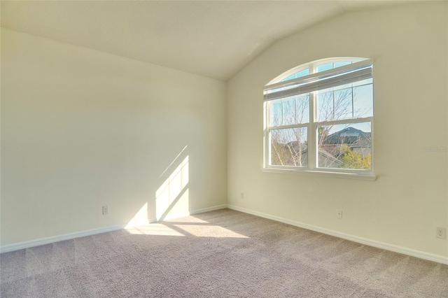 unfurnished room featuring vaulted ceiling, baseboards, and carpet floors