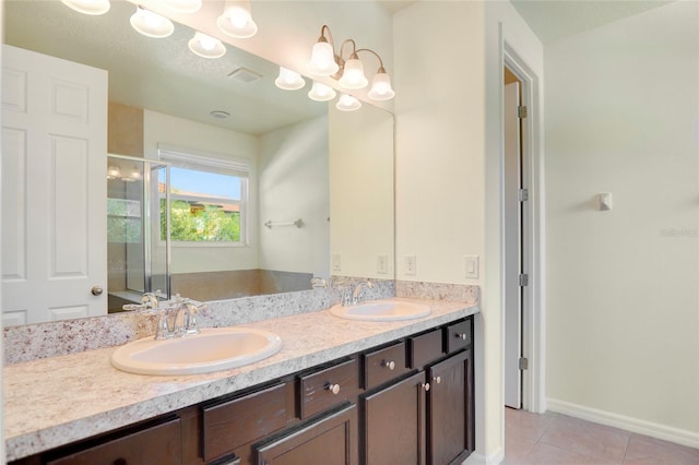 full bathroom with tile patterned flooring, double vanity, a stall shower, and a sink