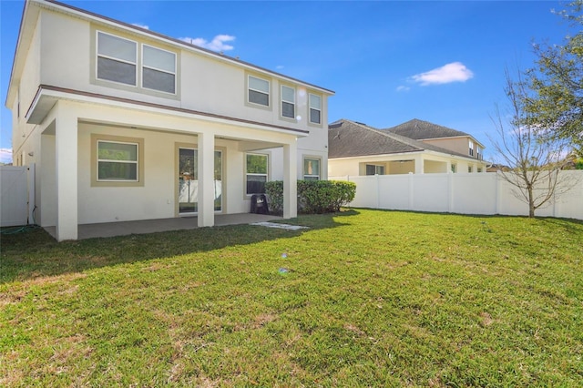 rear view of property featuring a patio, a yard, a fenced backyard, and stucco siding