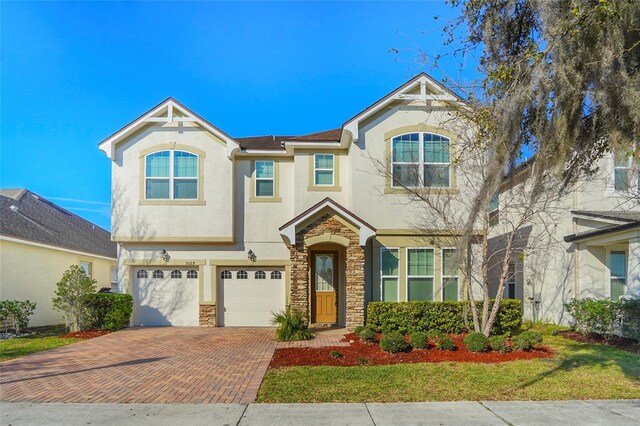 5029 Southlawn Ave, Orlando, FL 32811 - view of front facade featuring decorative driveway, an attached garage, stone siding, and stucco siding