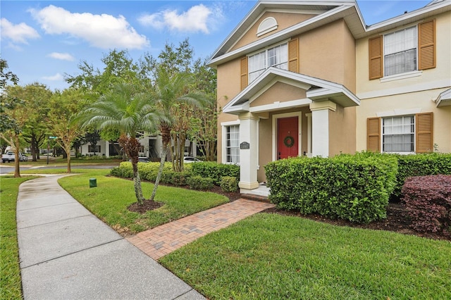 view of front facade featuring stucco siding and a front yard