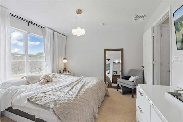 bedroom with light carpet, visible vents, and an inviting chandelier