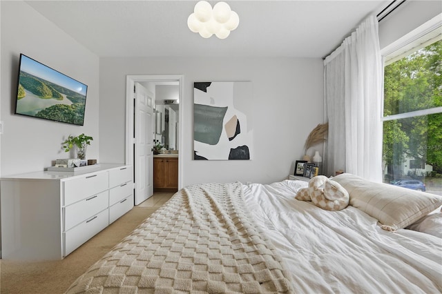 bedroom featuring light carpet and an inviting chandelier