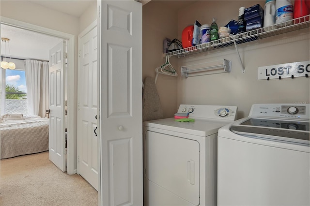 laundry area featuring washing machine and clothes dryer, laundry area, and light carpet