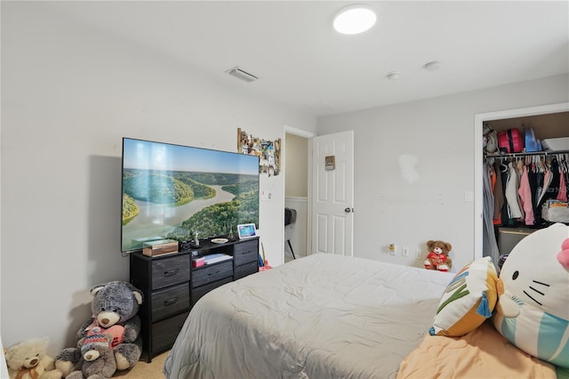 bedroom featuring a walk in closet, light colored carpet, visible vents, and a closet