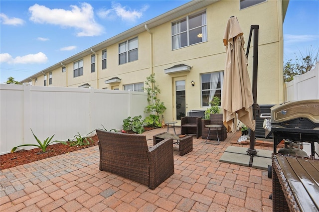 view of patio / terrace featuring an outdoor living space, a grill, and a fenced backyard