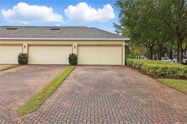 garage with decorative driveway