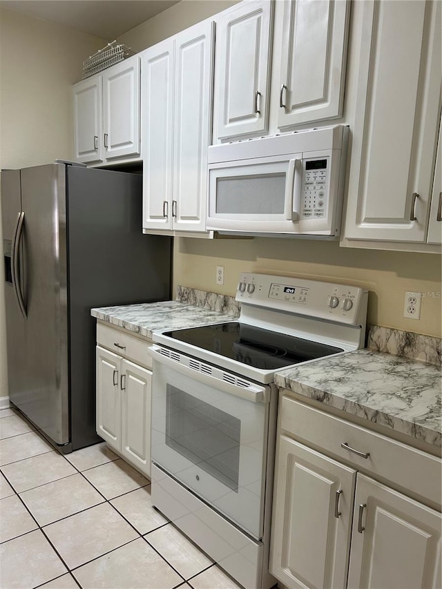 kitchen featuring white cabinetry, white appliances, and light tile patterned floors