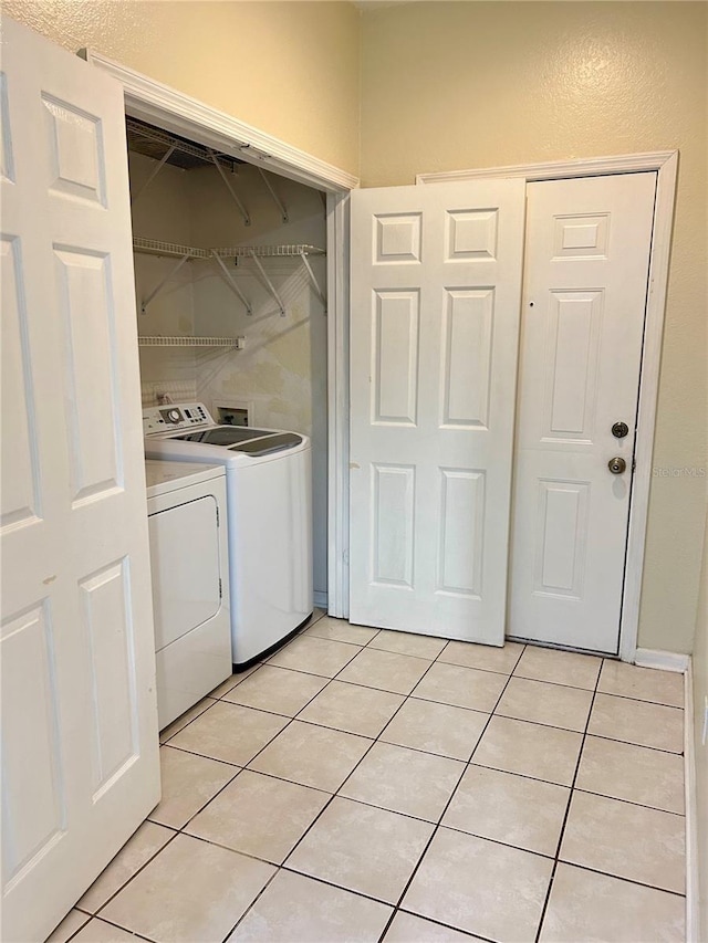 washroom with laundry area, light tile patterned flooring, and washing machine and dryer