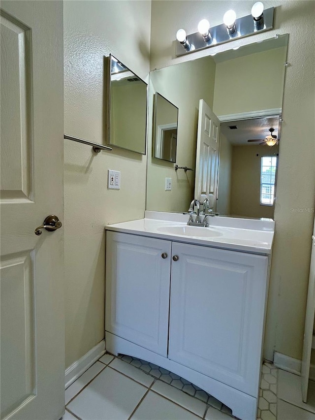 bathroom featuring tile patterned floors, baseboards, a ceiling fan, and vanity