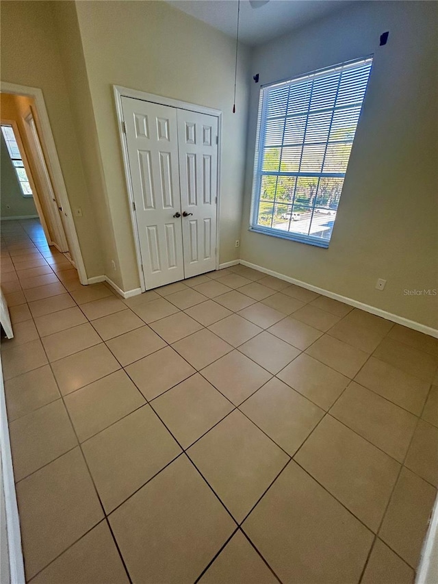 unfurnished bedroom with a closet, multiple windows, and baseboards