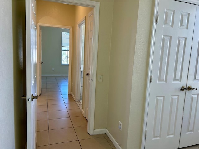 hall with light tile patterned floors and baseboards