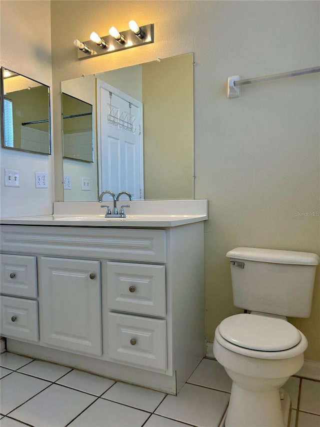 bathroom featuring vanity, toilet, and tile patterned flooring