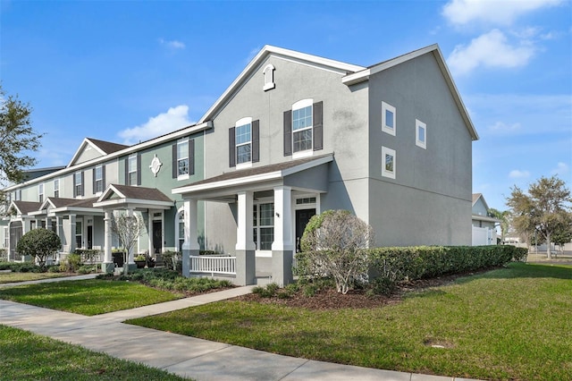 view of front of property with stucco siding, a residential view, covered porch, and a front lawn