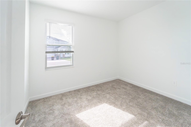 carpeted spare room with baseboards