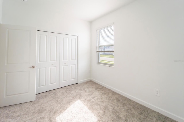 unfurnished bedroom featuring a closet, baseboards, and carpet floors