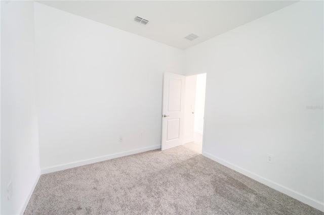 spare room featuring visible vents, carpet floors, and baseboards