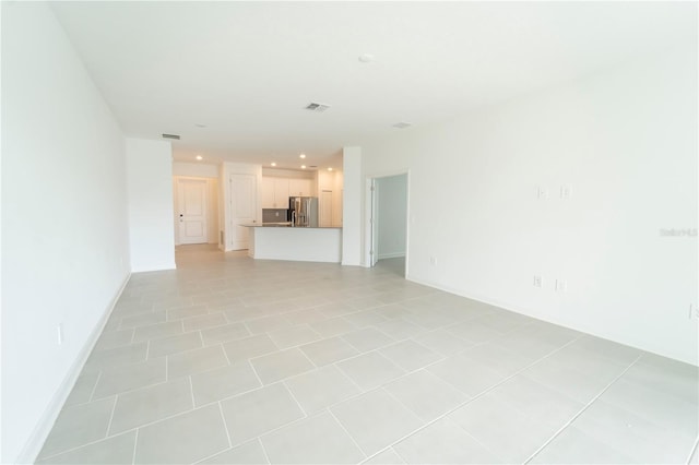 unfurnished living room with recessed lighting, light tile patterned floors, baseboards, and visible vents