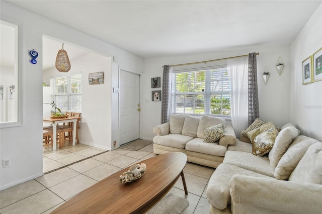 living room with light tile patterned floors, baseboards, and a wealth of natural light