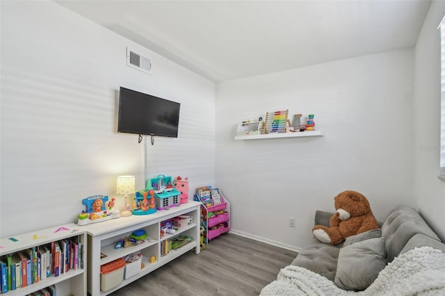 rec room featuring visible vents, baseboards, and wood finished floors