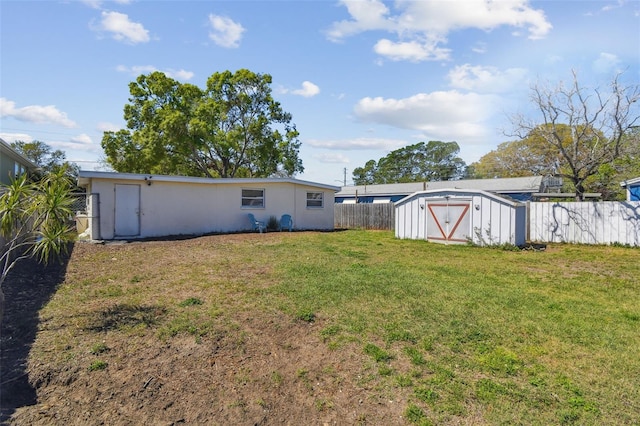 view of yard featuring an outdoor structure, a fenced backyard, and a shed