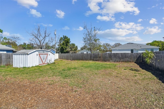 view of yard with an outbuilding, a storage unit, and a fenced backyard