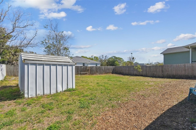 view of yard with an outbuilding, a fenced backyard, and a shed