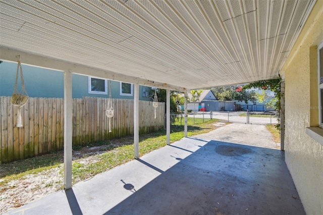 view of patio with a carport and fence