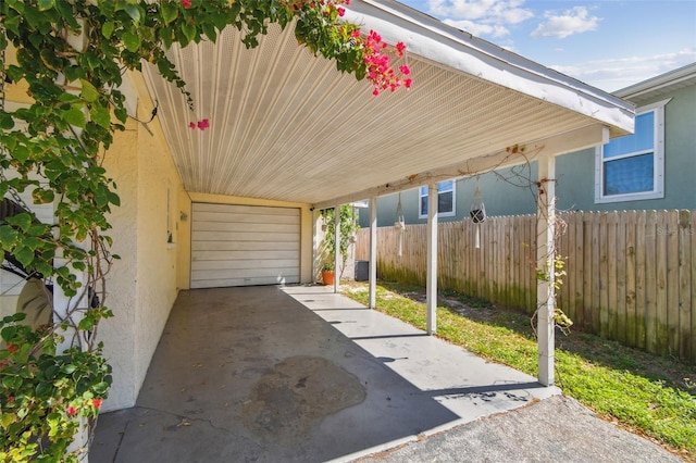 view of parking featuring a garage, a carport, and fence