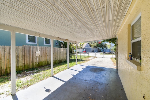 view of patio / terrace with an attached carport and fence